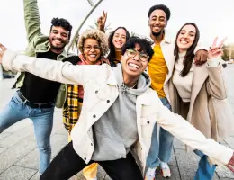 a diverse group of young adults smiling outside