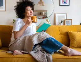 a woman sitting on a couch with a coffee mug